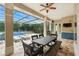 Extended covered patio with dining and lounging areas overlooking the pool and yard at 8214 Lake Serene Dr, Orlando, FL 32836