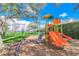 Community playground with slides, swings, and play equipment by the lake in a grassy area at 8214 Lake Serene Dr, Orlando, FL 32836