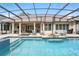 Screened-in pool with a hot tub, outdoor kitchen, lounge chairs and a dining area, perfect for entertaining and relaxation at 8214 Lake Serene Dr, Orlando, FL 32836