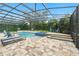 Spacious screened-in pool area featuring a built-in hot tub, lounge chairs and lush landscaping, perfect for outdoor enjoyment at 8214 Lake Serene Dr, Orlando, FL 32836