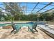 Inviting screened-in pool area with Adirondack chairs, pavers, inground pool, hot tub and lush landscaping, ideal for relaxation at 8214 Lake Serene Dr, Orlando, FL 32836