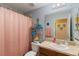 Cozy bathroom featuring a single sink vanity, shower, tub with shelving for storage at 832 Seneca Trl, St Cloud, FL 34772