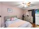 Relaxing bedroom with a comfortable bed, fan, dresser, and a pink accent color scheme at 832 Seneca Trl, St Cloud, FL 34772