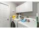Functional laundry room with white cabinets, washer, and dryer with some storage at 832 Seneca Trl, St Cloud, FL 34772