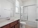 Clean, all-white bathroom with tile shower and cherry wood vanity at 8359 Lookout Pointe Dr, Windermere, FL 34786