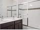 This bathroom features double sinks, a glass door tub and decorative tile at 8359 Lookout Pointe Dr, Windermere, FL 34786