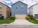 Two story home with tan garage door and green landscaping at 8359 Lookout Pointe Dr, Windermere, FL 34786