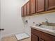 This laundry room has plenty of storage, a sink and a neutral tile floor at 8359 Lookout Pointe Dr, Windermere, FL 34786
