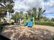 Bright and colorful playground featuring slides and swings, set in a safe, wood-chip covered area surrounded by trees at 8359 Lookout Pointe Dr, Windermere, FL 34786