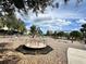 Community playground featuring a merry-go-round, swings, and a slide, set in a safe, wood-chip covered area at 8359 Lookout Pointe Dr, Windermere, FL 34786