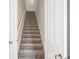 This staircase has neutral colored carpet, white walls and a white railing at 8359 Lookout Pointe Dr, Windermere, FL 34786