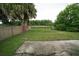 Large backyard featuring a chainlink fence, mature trees, and a concrete patio at 956 Florida Pkwy, Kissimmee, FL 34743