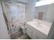 Bright bathroom featuring a vanity with storage and a shower with a decorative seashell shower curtain at 956 Florida Pkwy, Kissimmee, FL 34743