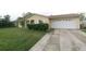 A well-manicured lawn adds curb appeal to the home's driveway and garage at 956 Florida Pkwy, Kissimmee, FL 34743
