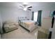 Cozy main bedroom featuring a ceiling fan, large bed, neutral colors and tile floor at 956 Florida Pkwy, Kissimmee, FL 34743