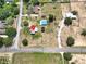 Aerial view of a spacious lot with a single-story home, surrounded by lush greenery and neighboring properties at 1 Coyer Rd, Haines City, FL 33844