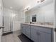 Bright bathroom featuring double sinks, gray cabinets, and a glass shower at 11051 Bostwick Aly, Winter Garden, FL 34787