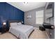 Comfortable bedroom with blue accent wall, a plush bed, and a mounted TV at 11051 Bostwick Aly, Winter Garden, FL 34787