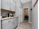 Well-lit laundry room with gray cabinets, granite countertops and stainless steel appliances at 11051 Bostwick Aly, Winter Garden, FL 34787