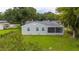 Backyard view of the house, showcasing a screened-in porch and well-maintained lawn at 113 W Division St, Winter Garden, FL 34787