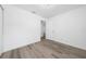Open bedroom with laminate flooring, white walls, and a doorway to the bathroom at 113 W Division St, Winter Garden, FL 34787