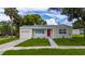Well-kept one-story home showcases an attached garage, a neatly landscaped yard, and a bright red door at 113 W Division St, Winter Garden, FL 34787