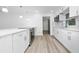 Renovated kitchen features stainless steel appliances, modern cabinetry, and vinyl plank floors at 113 W Division St, Winter Garden, FL 34787