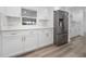 Bright kitchen with stainless steel refrigerator, white shaker cabinets and countertops at 113 W Division St, Winter Garden, FL 34787