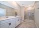 Bathroom features double sink vanity, large mirror, and glass-enclosed shower at 1173 Trappers Trail Loop, Champions Gate, FL 33896