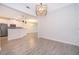 Open concept living area showcases the kitchen and dining spaces with wood-look tile flooring at 1173 Trappers Trail Loop, Champions Gate, FL 33896