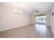 Bright living room with wood-look tile flooring and sliding glass doors to the lanai at 1173 Trappers Trail Loop, Champions Gate, FL 33896