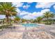 Relaxing community pool with lounge chairs and palm trees on a sunny day at 1173 Trappers Trail Loop, Champions Gate, FL 33896