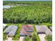 Aerial view of a home with screened patio surrounded by lush greenery and a lake in the distance at 125 Prima Dr, Poinciana, FL 34759
