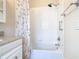 Bright bathroom with a bathtub, shower, and vanity offering stylish fixtures and a patterned shower curtain at 125 Prima Dr, Poinciana, FL 34759