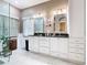 Elegant bathroom featuring dual sinks, white cabinetry, and modern fixtures, offering a bright and functional space at 125 Prima Dr, Poinciana, FL 34759