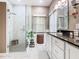 Bathroom with glass enclosed walk-in shower, featuring neutral tones, white cabinetry, and marble tile floors at 125 Prima Dr, Poinciana, FL 34759