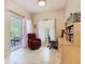 Bright room featuring a comfortable red chair, tile flooring, and sliding doors to an enclosed outdoor patio at 125 Prima Dr, Poinciana, FL 34759