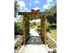 Inviting butterfly garden entrance with lush greenery and a charming wooden trellis pathway, offering a serene outdoor experience at 125 Prima Dr, Poinciana, FL 34759