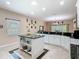 Bright kitchen with island, pendant lighting, white cabinets, and black countertops at 125 Prima Dr, Poinciana, FL 34759