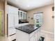 Kitchen features granite counters, center island, white cabinets, and stainless refrigerator at 125 Prima Dr, Poinciana, FL 34759