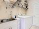 Functional laundry room with stainless steel sink, cabinets, and modern washer and dryer at 125 Prima Dr, Poinciana, FL 34759