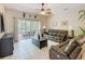 Bright living room with tile flooring, ceiling fan, and sliding doors to the lanai at 125 Prima Dr, Poinciana, FL 34759