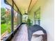 Relaxing screened-in patio with brick flooring, ceiling fan, and view of the lush, green backyard at 125 Prima Dr, Poinciana, FL 34759