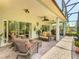Inviting patio with comfortable wicker furniture, brick flooring, and tranquil views of the surrounding landscape at 125 Prima Dr, Poinciana, FL 34759