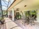 Open-air patio with brick flooring, ceiling fans, and cozy seating areas, perfect for outdoor relaxation and entertainment at 125 Prima Dr, Poinciana, FL 34759