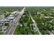 A birds eye view of a small home on a corner lot, near a main road, with lush tree coverage at 1322 New York Ave, St Cloud, FL 34769