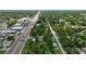 A birds eye view of a small home on a corner lot, near a main road, with lush tree coverage at 1322 New York Ave, St Cloud, FL 34769