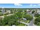 Aerial view of a neighborhood intersection featuring a quaint home, trees and an ocean view in the distance at 1322 New York Ave, St Cloud, FL 34769