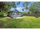 Backyard featuring a lush lawn, mature trees, a concrete patio, and a fenced perimeter at 1322 New York Ave, St Cloud, FL 34769