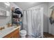 Bathroom featuring a shower with a white curtain, a sink, and dark shelves for storage at 1322 New York Ave, St Cloud, FL 34769